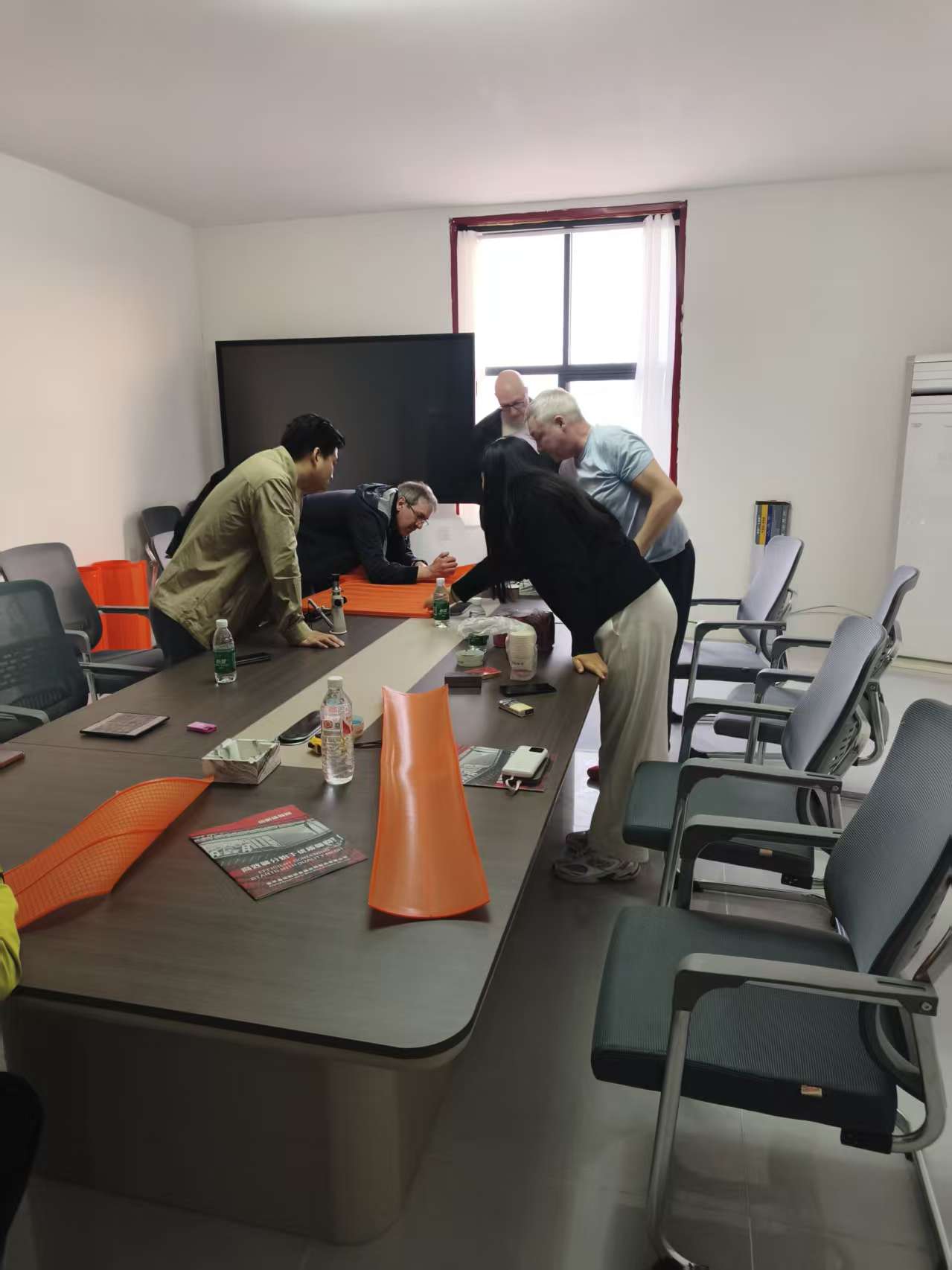 Face-to-face discussion around polyurethane fine screen samples in the meeting room.